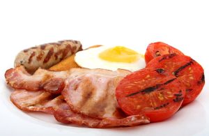 A perfectly cooked steak alongside scrambled eggs on a plate, representing the steak and egg diet.