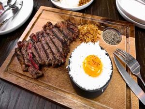 Steak and egg quiche with a side of fruit salad