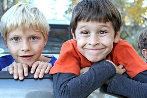 Two happy children proudly smiling, symbolizing the joy of mastering complex topics like present indefinite tense examples.