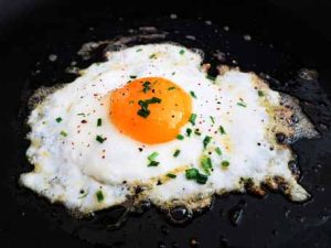 Close-up of sunny-side-up egg, showcasing a key component of protein in steak and eggs