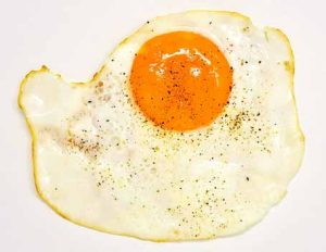 Perfectly fried egg ready to complement high-protein steak and eggs meal