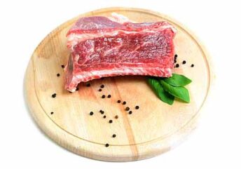 Red meat on a wooden board with black pepper – is red meat bad for cholesterol than white meat?