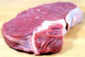 Red meat on a wooden board with black pepper – is red meat bad for cholesterol than white meat?