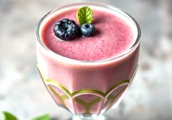 Berry and spinach smoothie in a glass, soft food for braces.