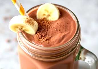 Thick chocolate peanut butter protein smoothie in a glass jar, perfect post-workout fuel.