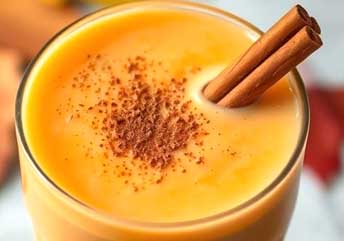 Creamy pumpkin pie spice smoothie topped with whipped cream and cinnamon, perfect for fall.