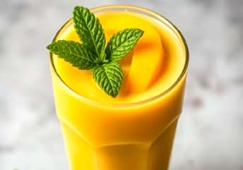 Smooth, creamy mango yogurt smoothie in a glass, ideal soft food for braces.