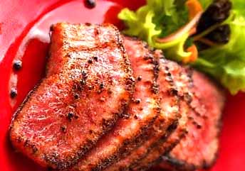 Seared Ahi Tuna steak sliced and served rare with sesame crust and soy dipping sauce