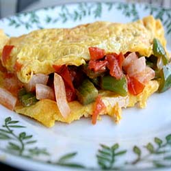 A hot skillet with a folded omelette and fresh herbs, detailing Omelette Calories 2 Egg 3 Egg 4 Egg.